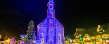 igreja com luses de natal e deocração de natal em rua em Gramado